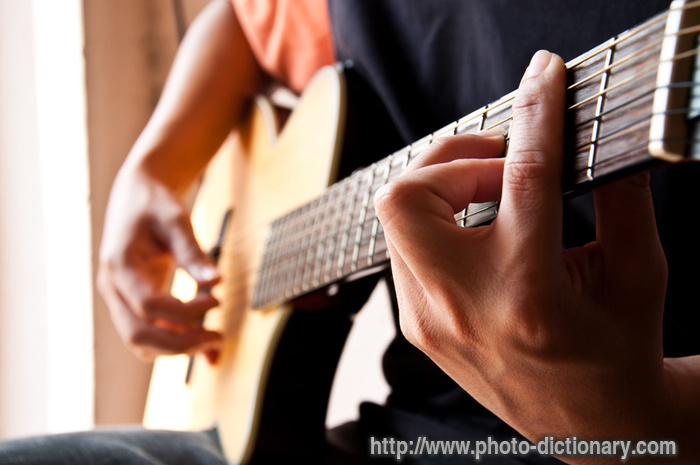 playing guitar - photo/picture definition - playing guitar word and phrase image